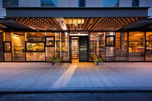 A hotel entrance with a reception area, a bar, and a coffee shop.