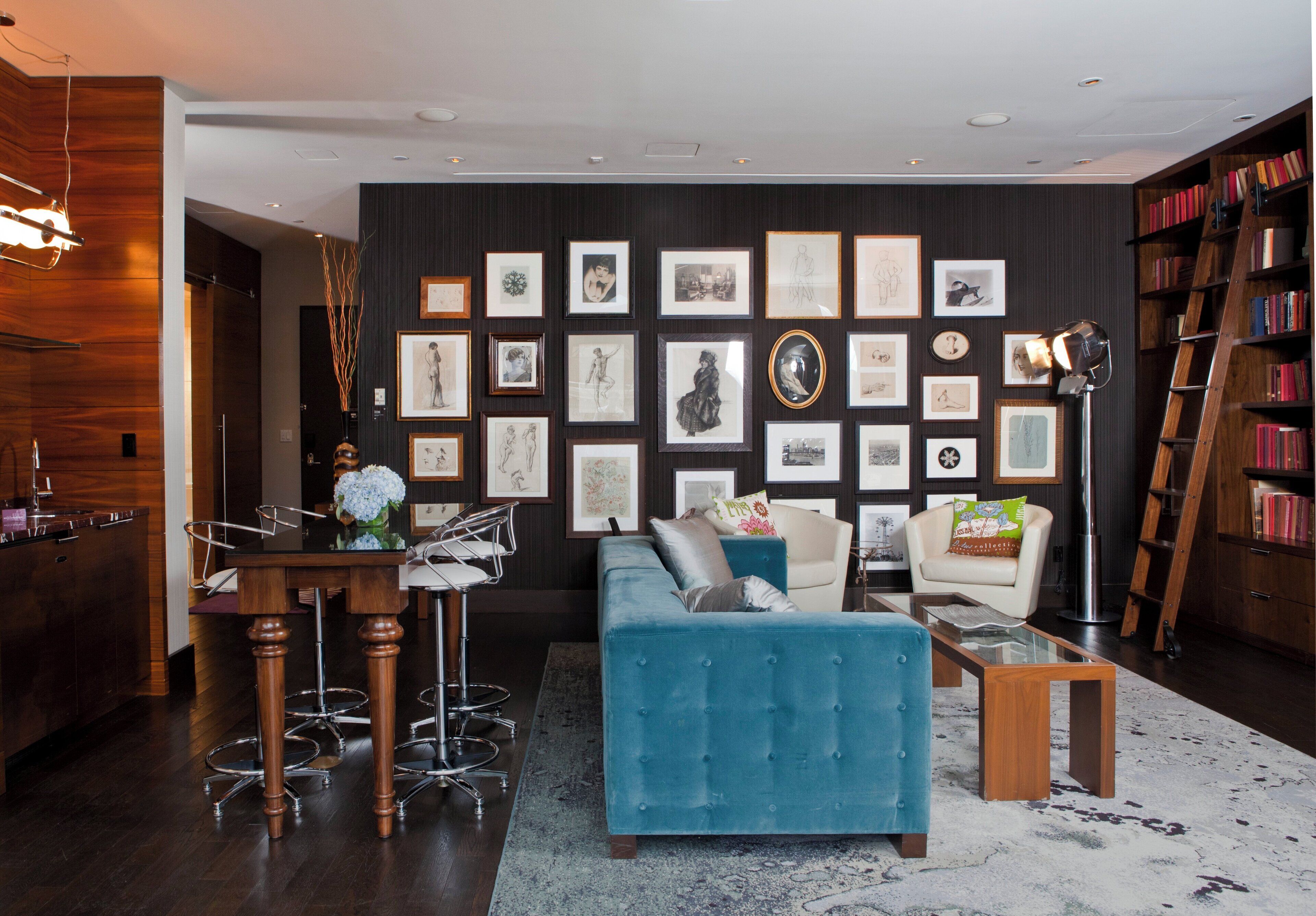 A modern living room with a blue sofa, a coffee table, and a bookshelf.