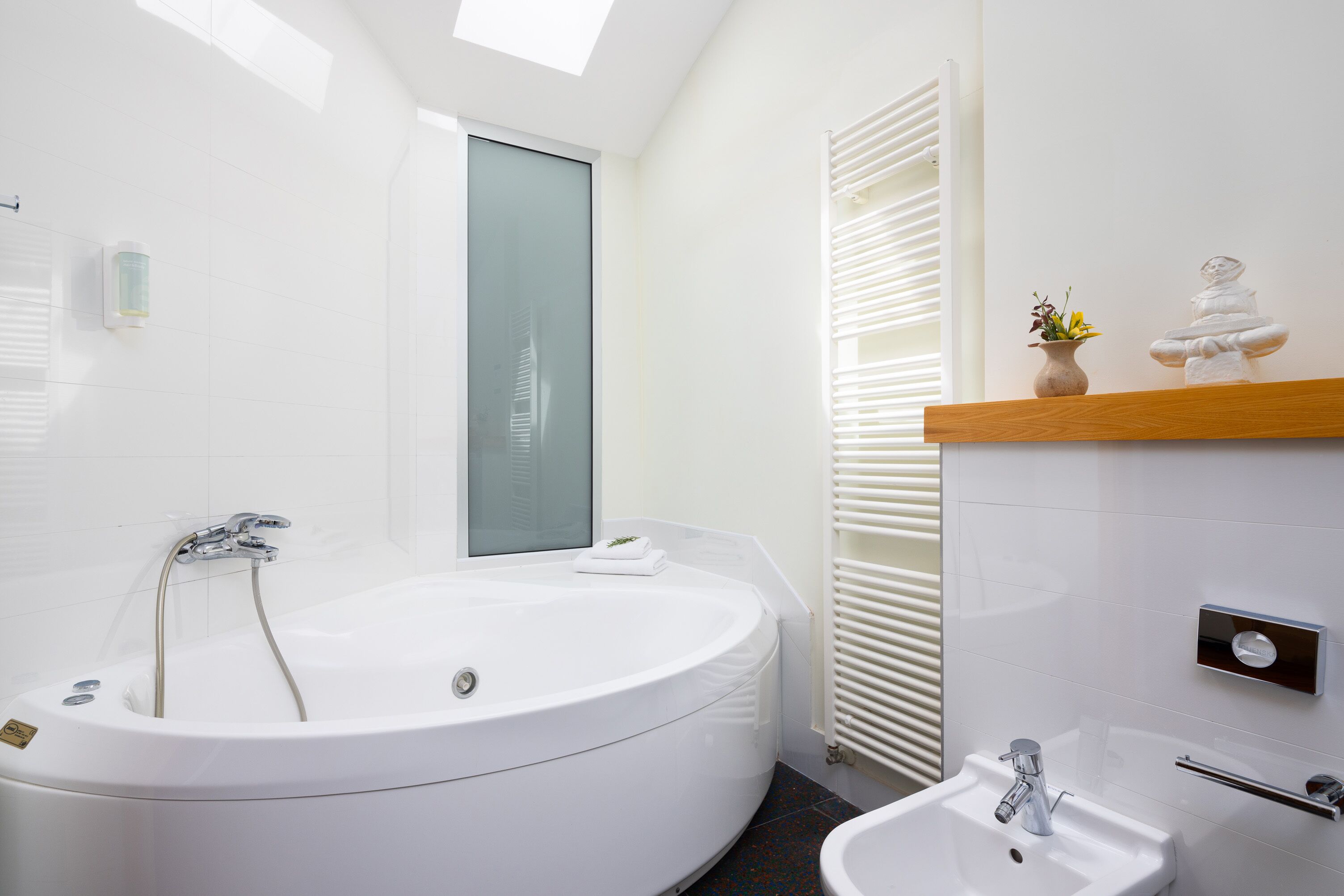 A modern bathroom with a freestanding bathtub, a sink, and a mirror.