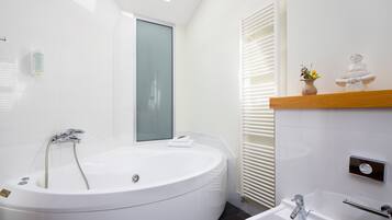 A modern bathroom with a freestanding bathtub, a sink, and a mirror.