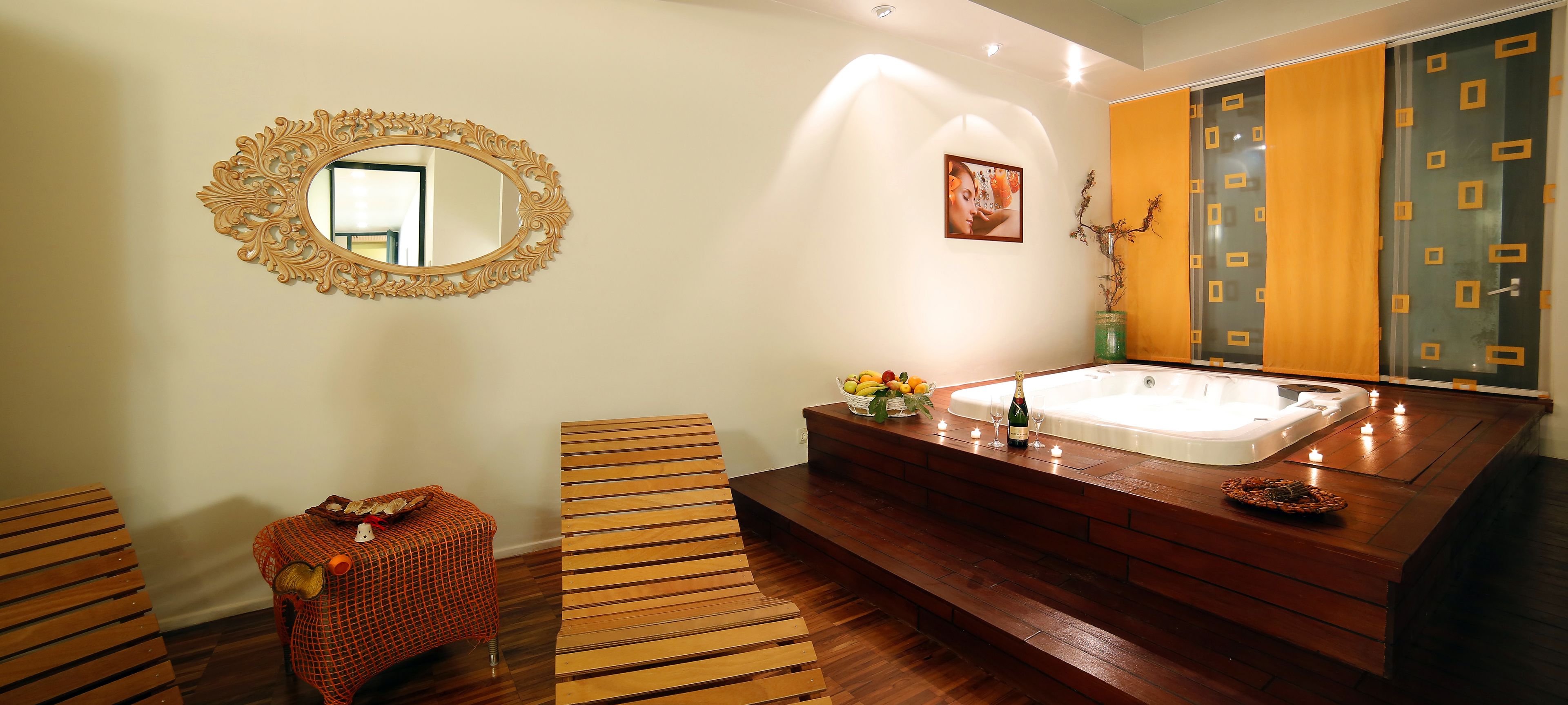 A bathroom with a wooden vanity, a large mirror, and a bathtub.