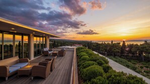 A rooftop terrace with outdoor seating and a view of the sunset over the sea. - Aminess Vival Velaris Resort  (Supetar)