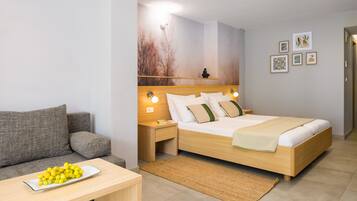 Un dormitorio moderno con una cama de madera, un sofá gris y una mesita de noche con una lámpara.