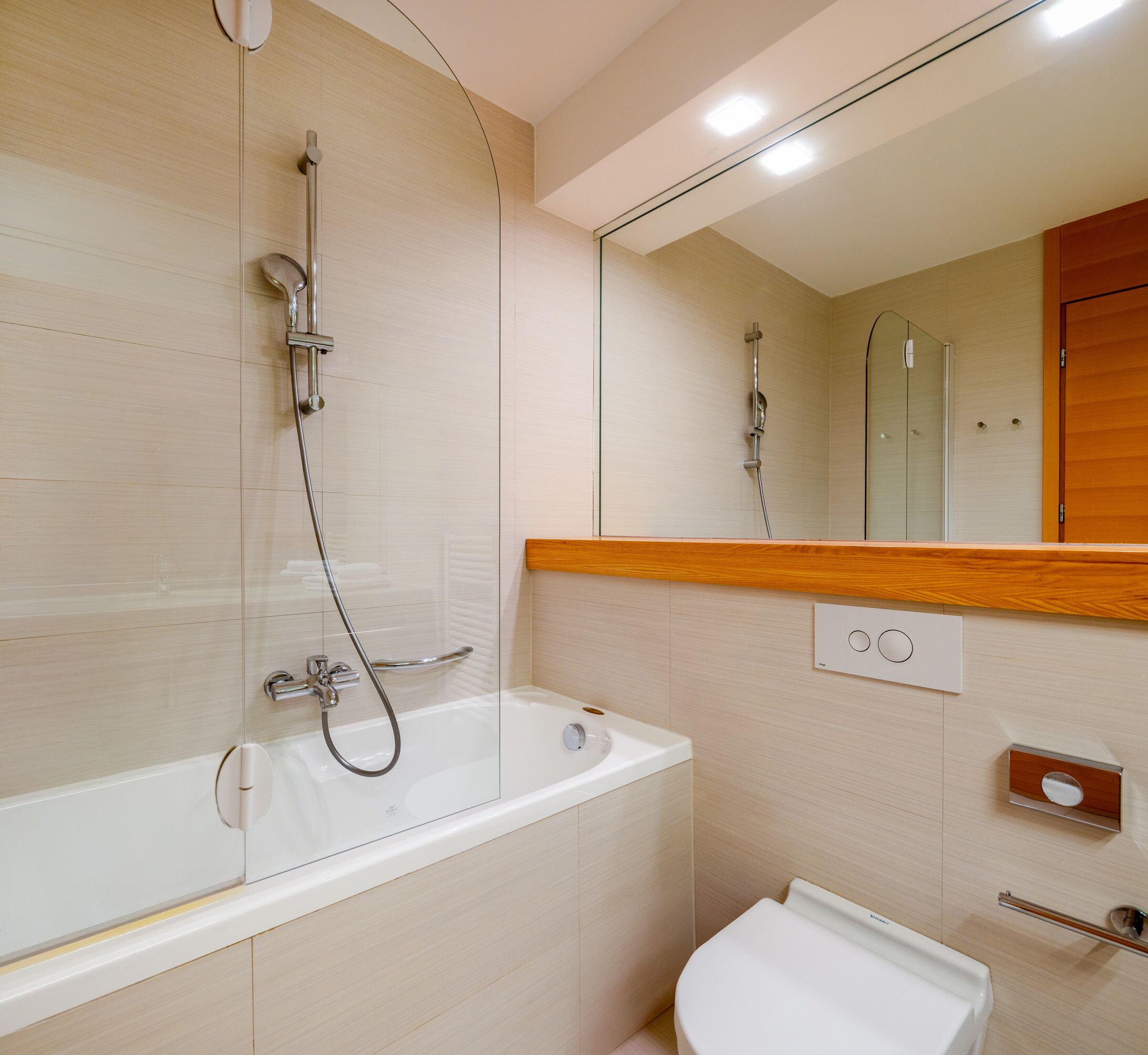 Un baño moderno con bañera, inodoro y ducha.