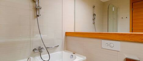 Un baño moderno con bañera, inodoro y ducha.