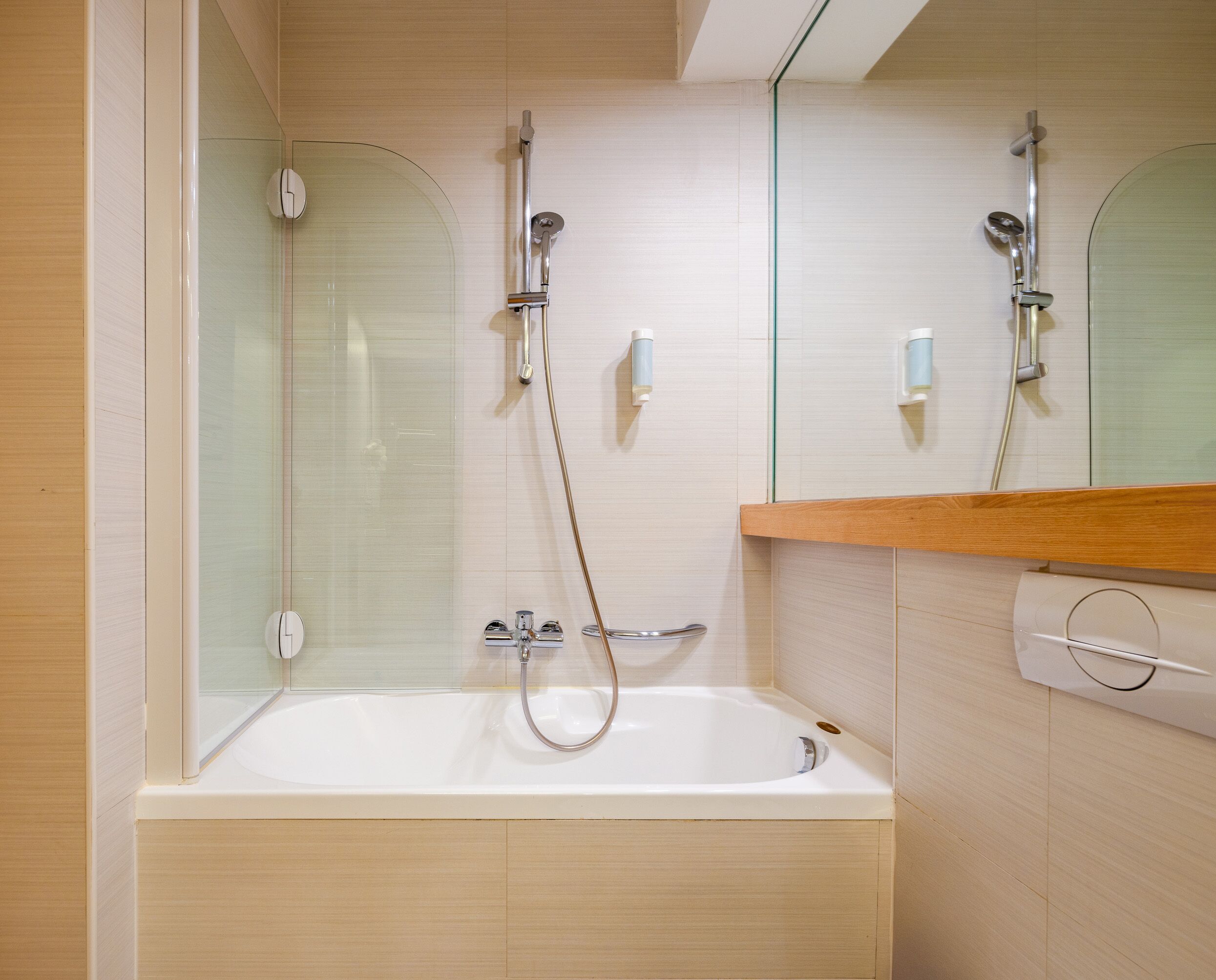 Une salle de bain moderne avec une douche à parois de verre, une baignoire sur pieds et un meuble-lavabo en bois.