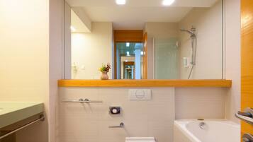 Un baño moderno con cabina de ducha de vidrio, bañera y retrete.