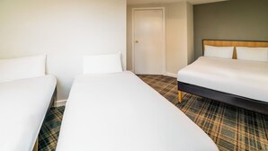 A hotel room with two single beds, a door, and a carpeted floor. - Adamton Country House Hotel (Prestwick)