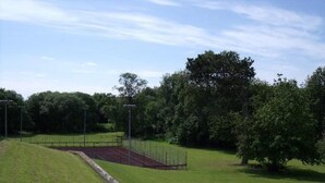 A grassy field with a running track and a fence. - Adamton Country House Hotel (Prestwick)