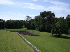 Un campo cubierto de hierba con una pista de atletismo y una valla.