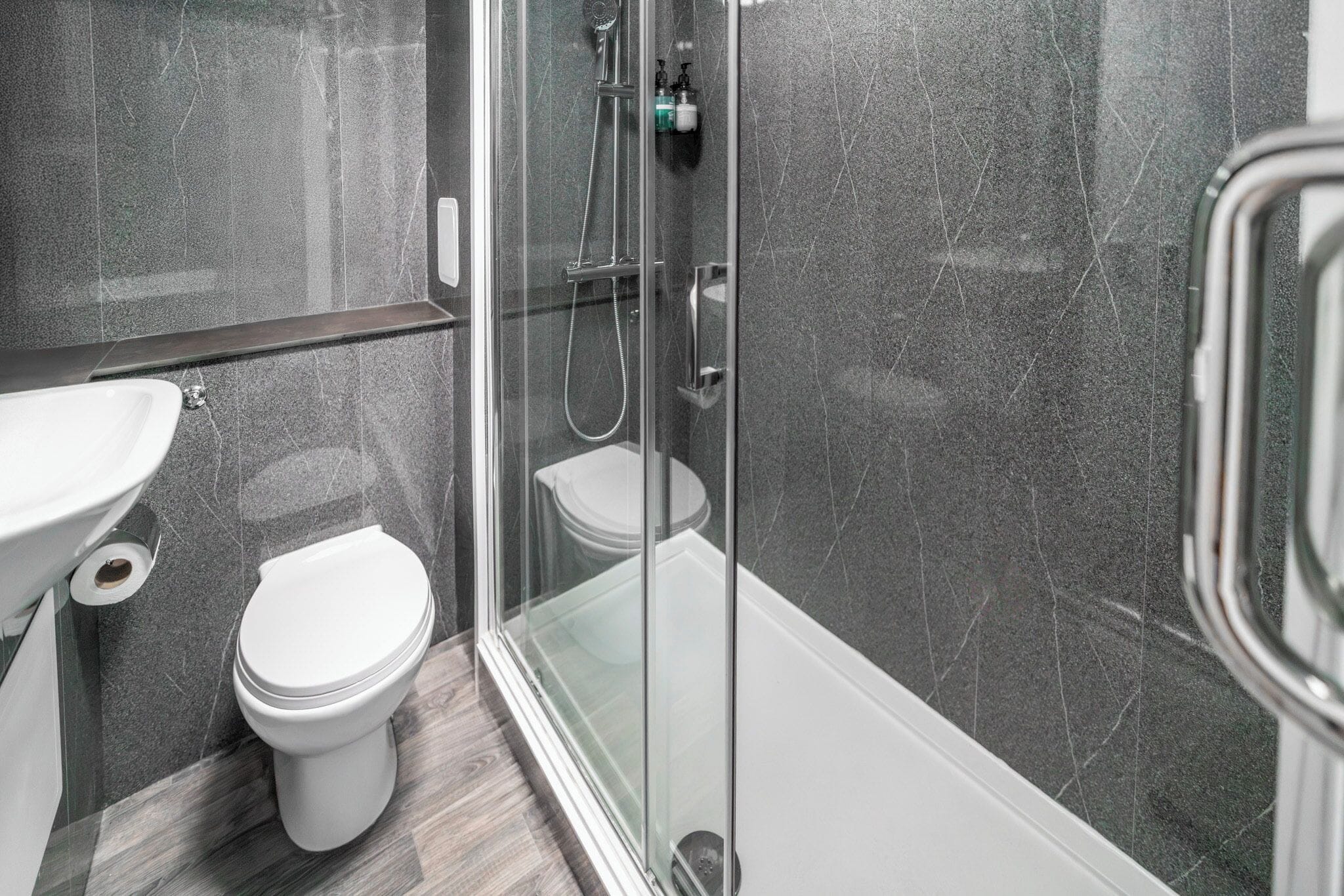 Une salle de bain moderne avec une douche à parois de verre, des toilettes et un lavabo.
