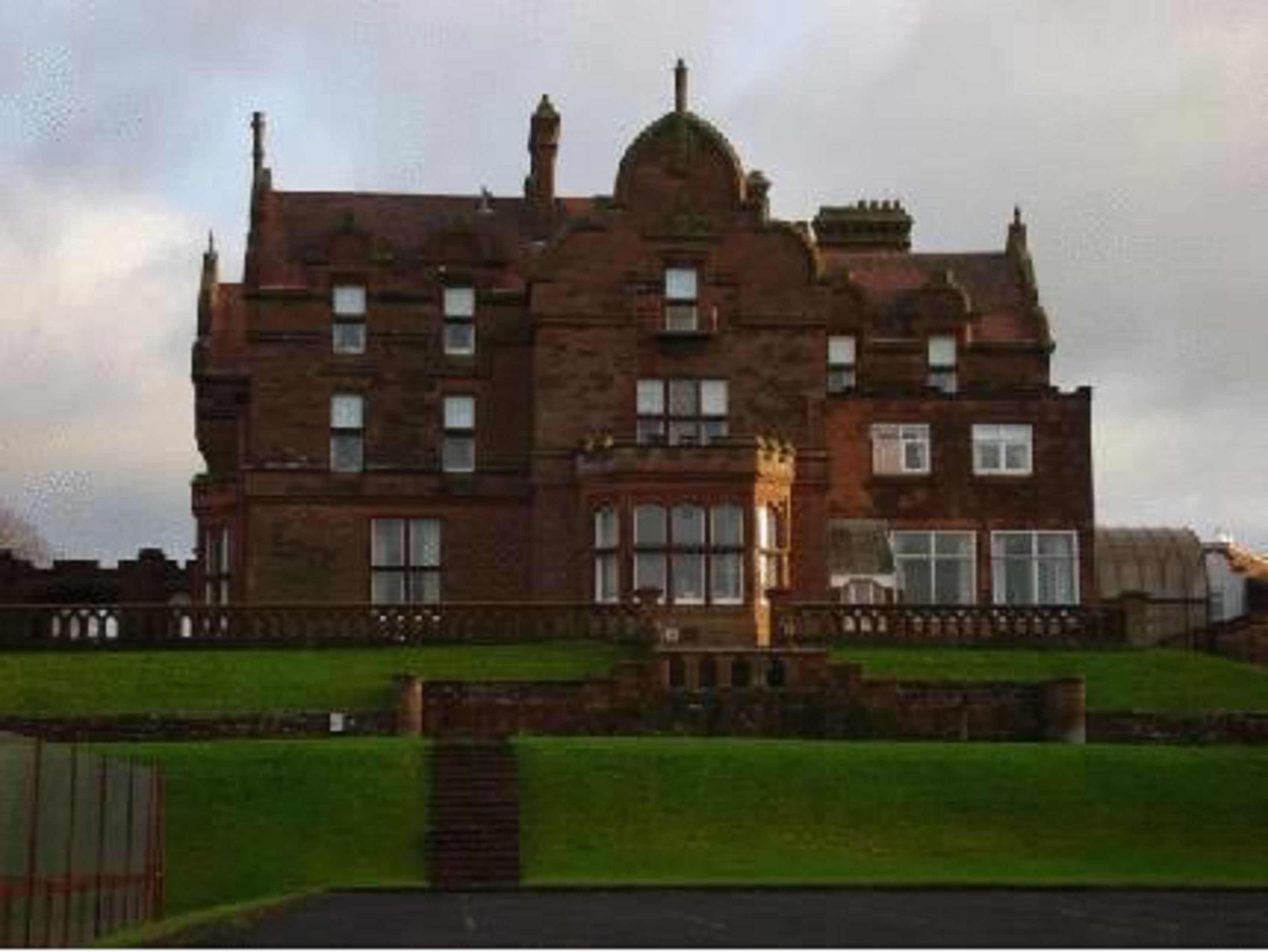 A large, historic building with multiple windows and a prominent central tower.
