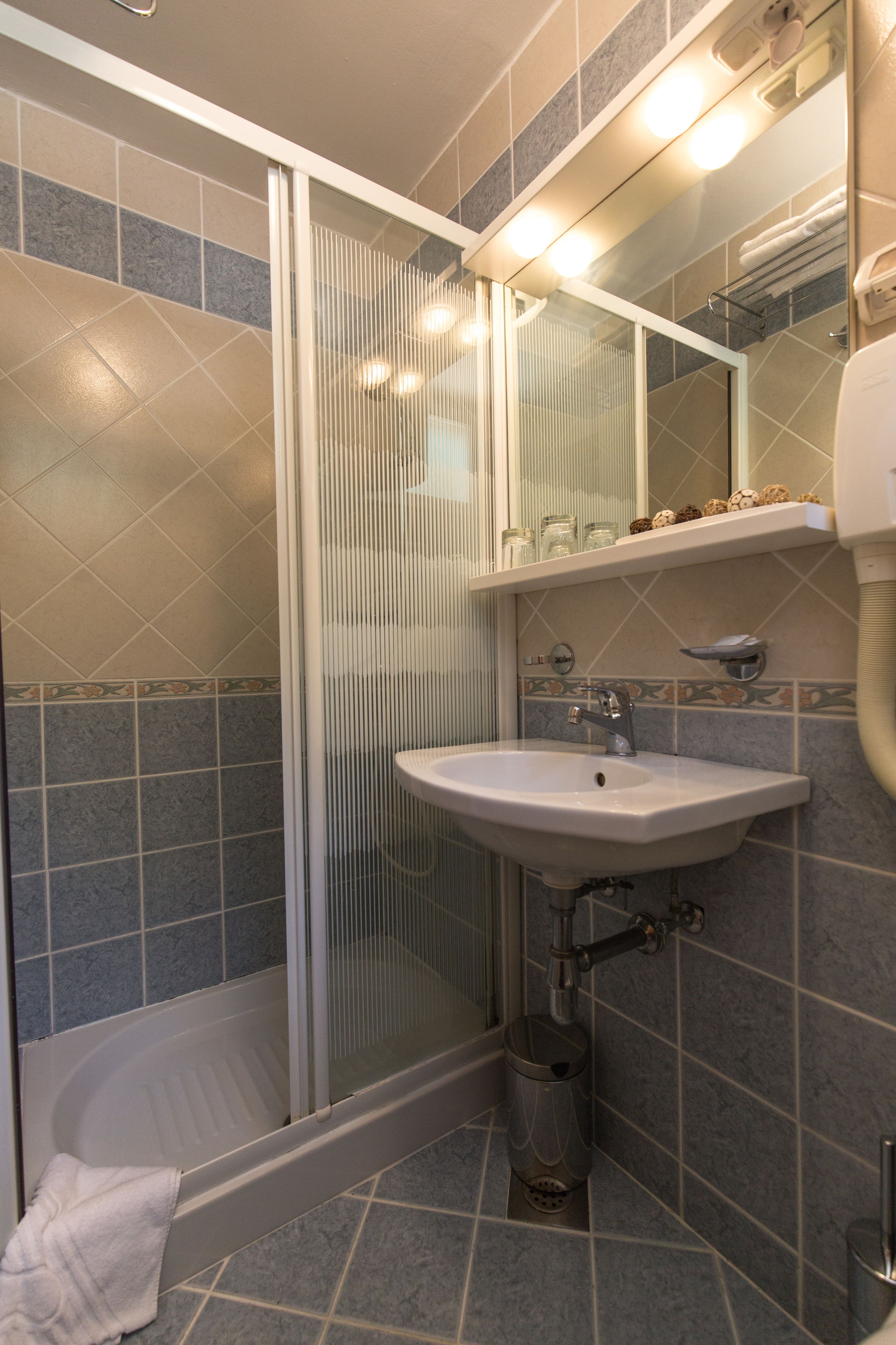 Un baño con ducha, lavabo y espejo.
