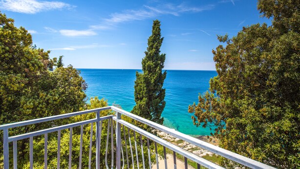 A coastal view from a balcony with a railing, overlooking the sea and trees. - Horizont Resort (Pula)