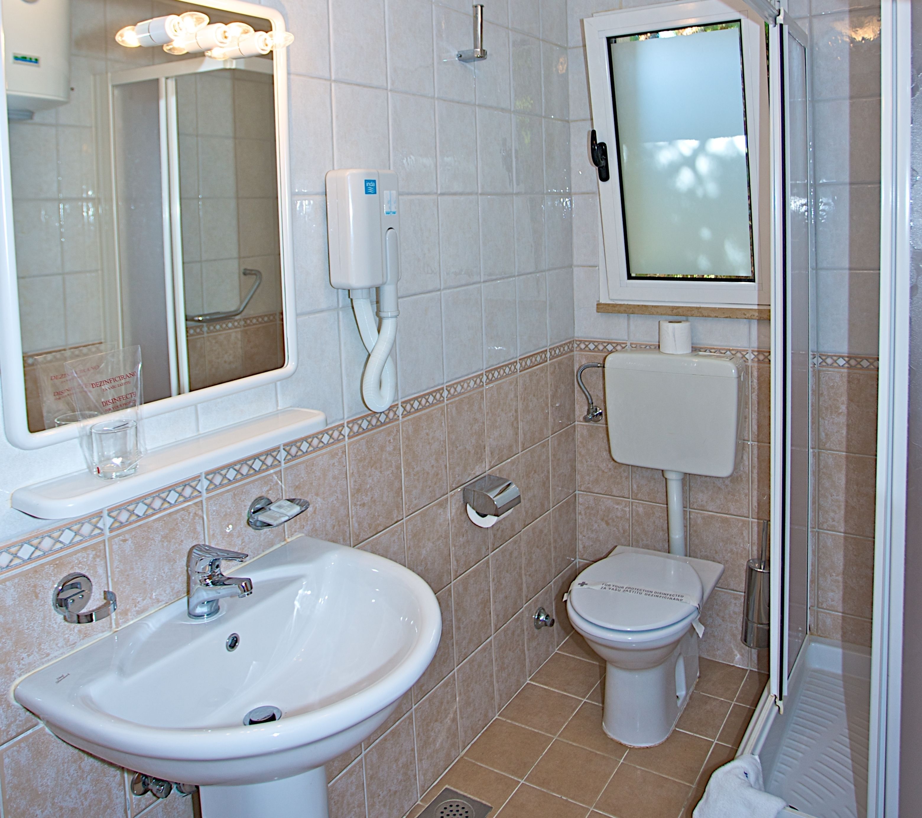 A bathroom with a sink, toilet, and a mirror.
