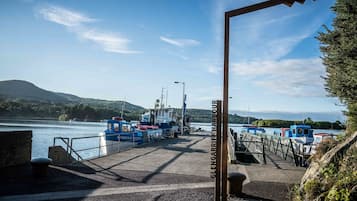 Une jetée où sont amarrés des bateaux, un ciel dégagé et un panneau indiquant « GLENGARRIFF HARBOROUGH ».