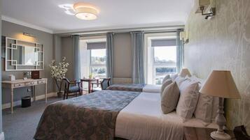 Une chambre d’hôtel avec un grand lit, un bureau, une chaise et une fenêtre avec des rideaux.