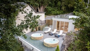 A rooftop patio with two hot tubs, lounge chairs, and a glass balustrade. - Eccles Hotel Glengarriff (Glengarriff)