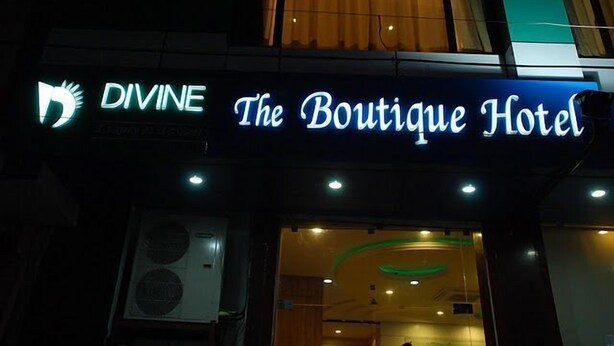 A hotel sign with the name "The Boutique Hotel" and a logo that includes a stylized sun and the word "DIVINE". - Divine the Boutique Hotel (Jaipur)