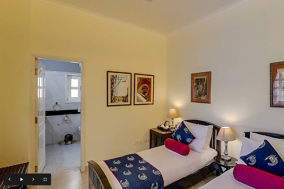 A hotel room with a bed, bedside tables, and wall-mounted artwork.