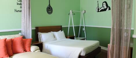 Una habitación con una cama, un sofá pequeño y una silla colgante.