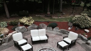 A circular outdoor seating area with four wicker chairs and a central fire pit. - Maple View Bed and Breakfast (Nanaimo)