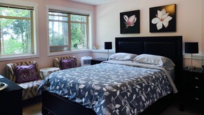 A bedroom with a bed, two windows, a ceiling light, and two wall-mounted flower paintings. - Maple View Bed and Breakfast (Nanaimo)