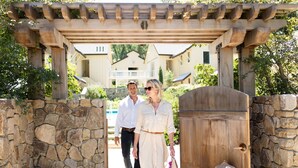 A stone wall entrance with a wooden pergola overhead. - Farmhouse Inn (Forestville)