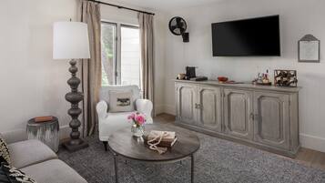 A living room with a sofa, a coffee table, a lamp, a TV, and a cabinet.