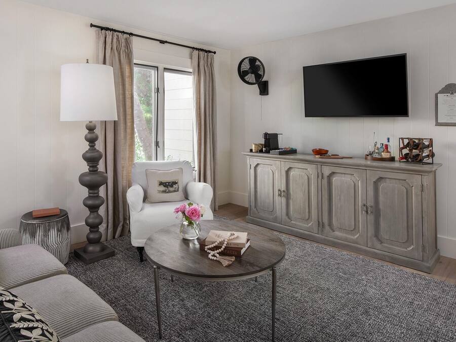 A living room with a sofa, a coffee table, a lamp, a TV, and a cabinet.