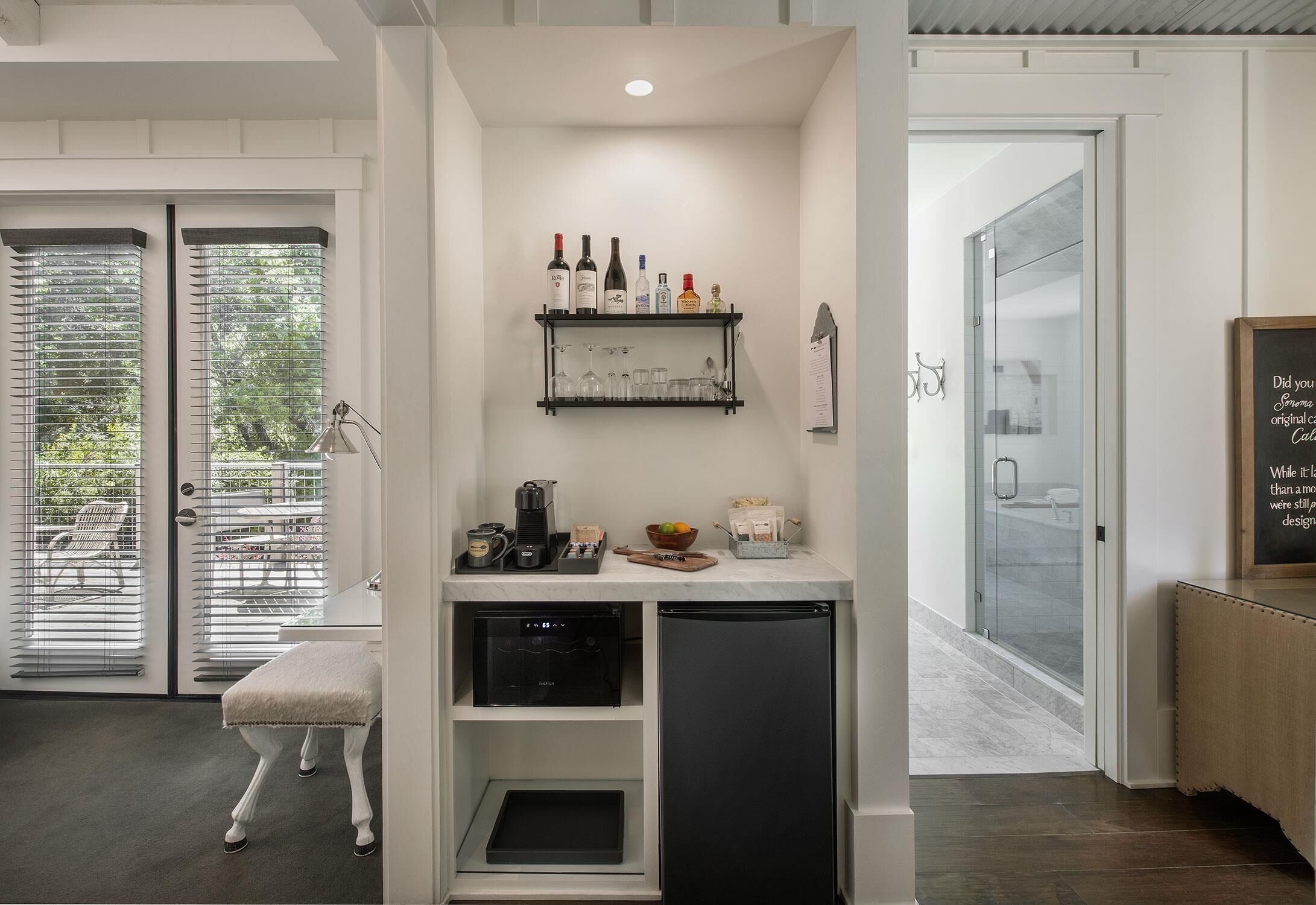 A compact kitchen with a built-in dishwasher, a coffee machine, and a small countertop with various items.
