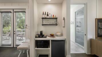 A compact kitchen with a built-in dishwasher, a coffee machine, and a small countertop with various items.