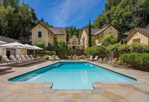 A swimming pool with lounge chairs and a stone deck.