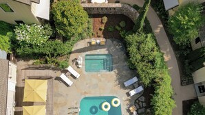 An aerial view of a residential area with a swimming pool, lounge chairs, and umbrellas. - Farmhouse Inn (Forestville)