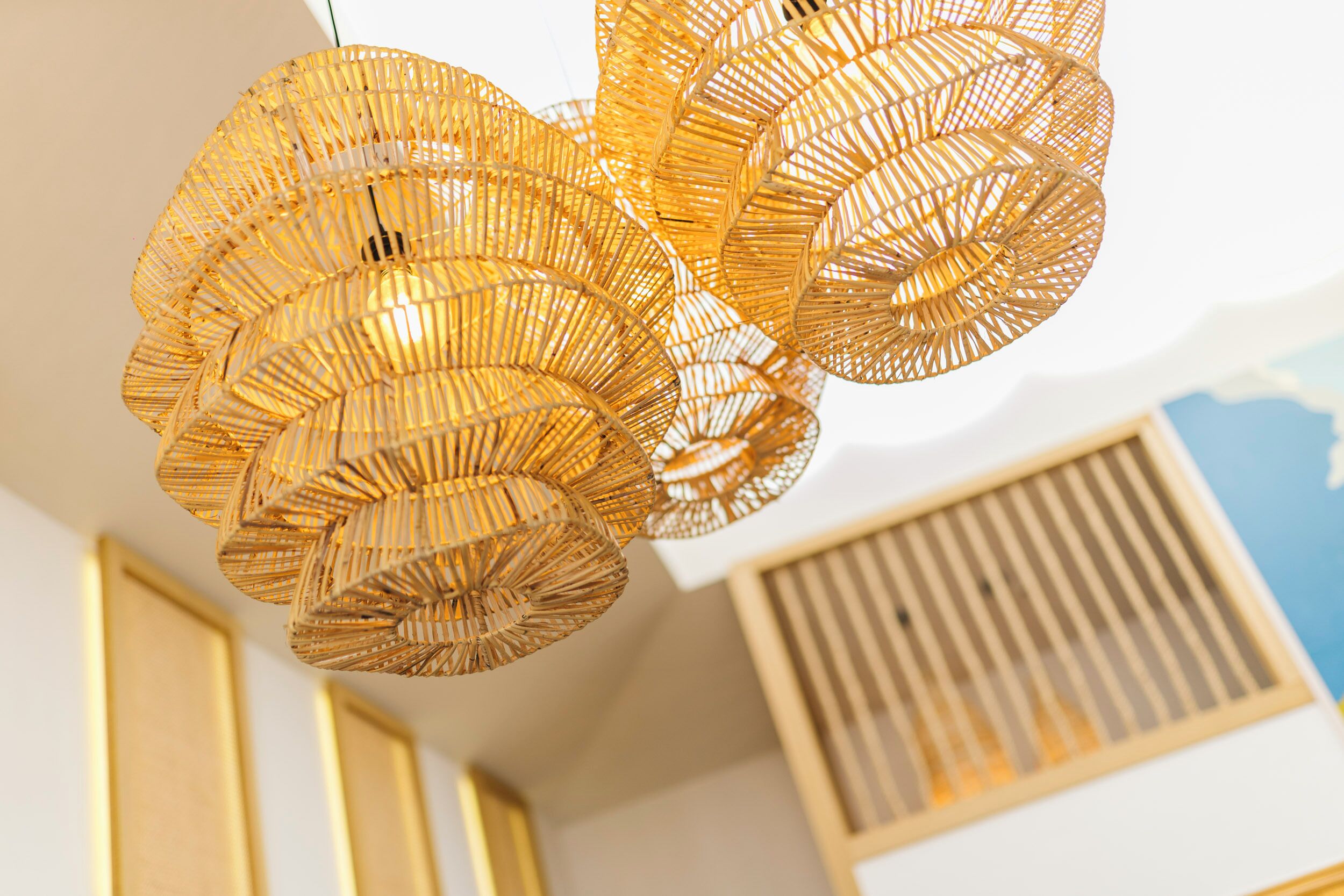 A ceiling with a woven, circular light fixture.