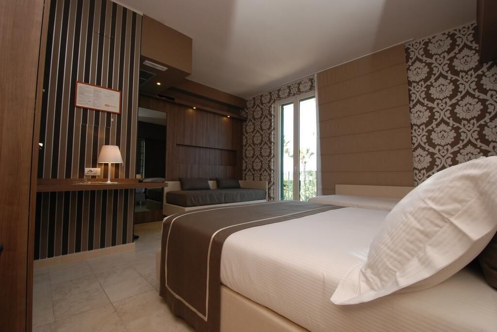 Une chambre d’hôtel avec un grand lit, un bureau et un coin salon.