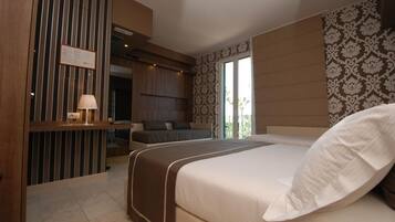 Une chambre d’hôtel avec un grand lit, un bureau et un coin salon.