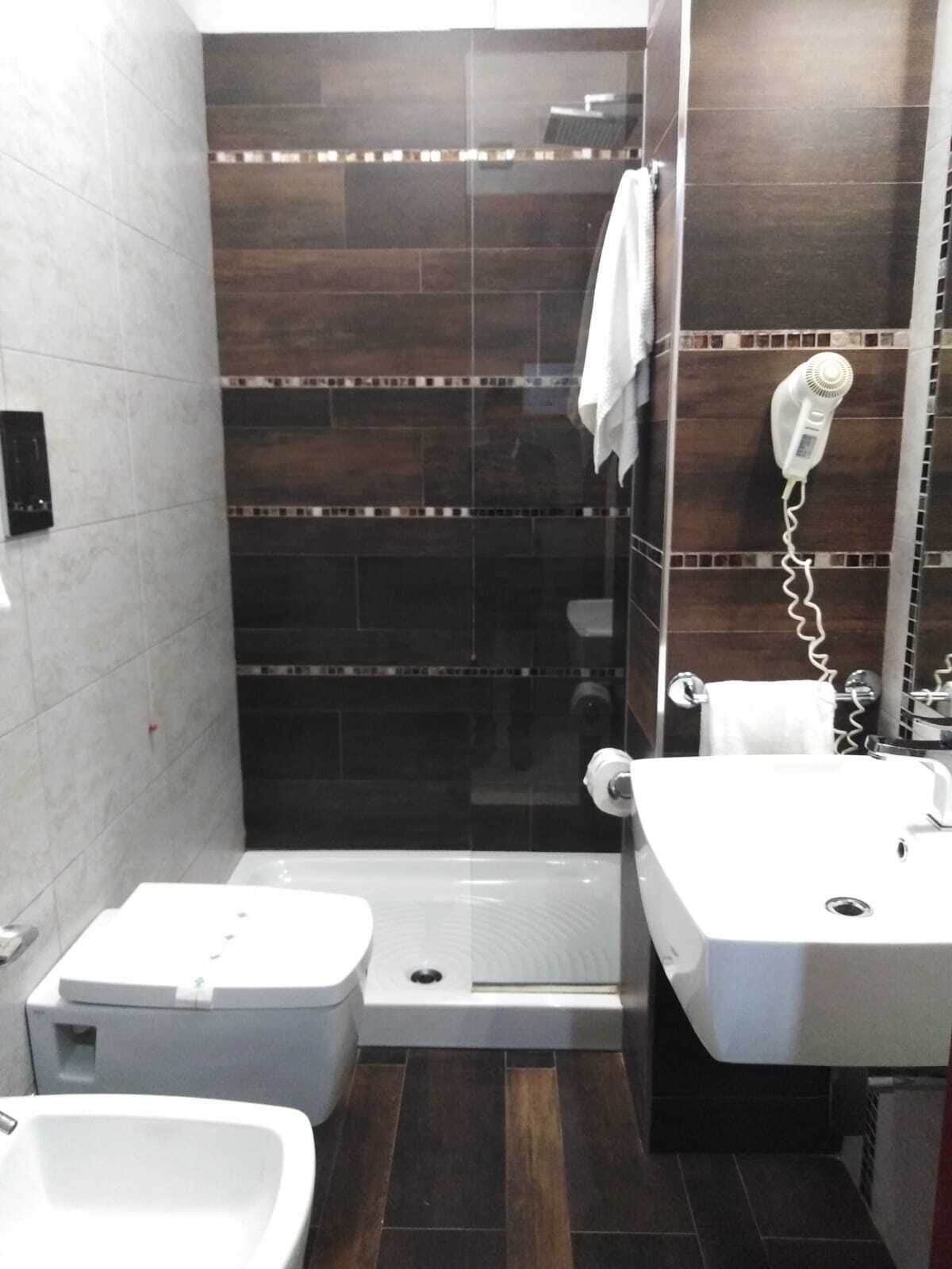Ein kleines Badezimmer mit Dusche, Toilette und Waschbecken.