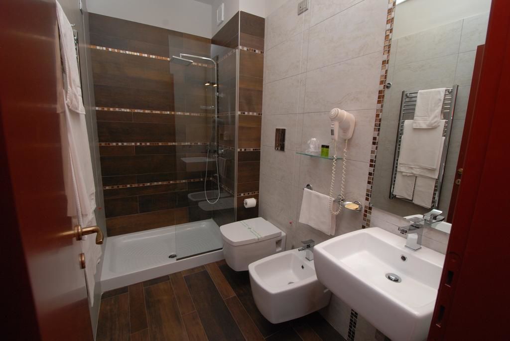 A modern bathroom with a glass-enclosed shower, a white sink, and a toilet.