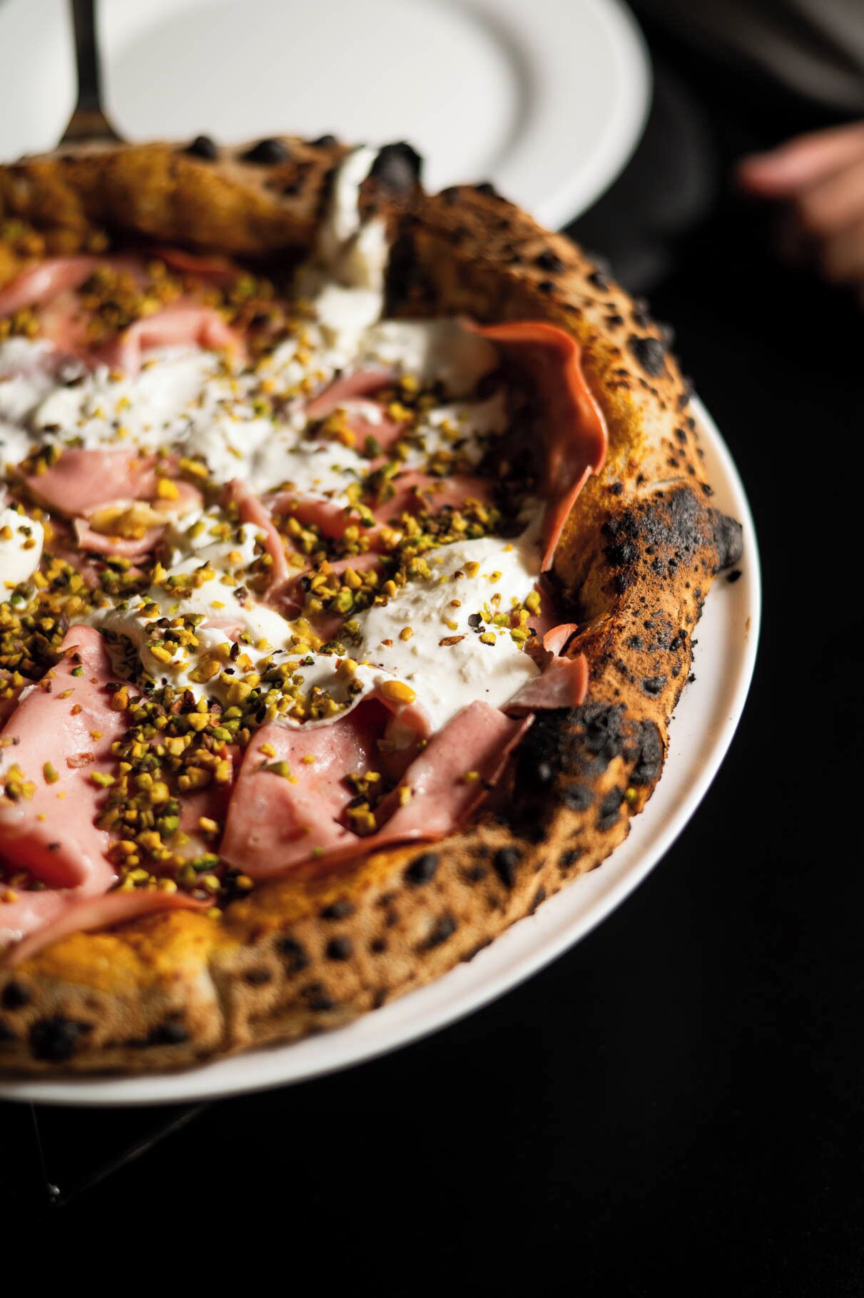 Une pizza garnie, servie sur une assiette blanche.