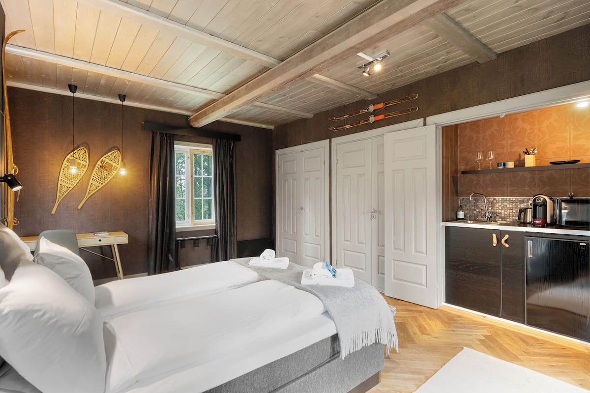 Ein modernes Hotelzimmer mit einem großen Bett, einem Schreibtisch, einem Kleiderschrank und einer Küchenzeile.