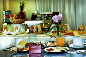 A breakfast buffet with various pastries, fruits, and beverages. - Alcalá Apart hotel (La Paz)