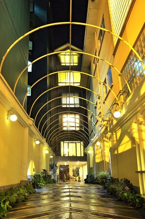 A covered walkway with a glass ceiling, leading to a building entrance. - Alcalá Apart hotel (La Paz)