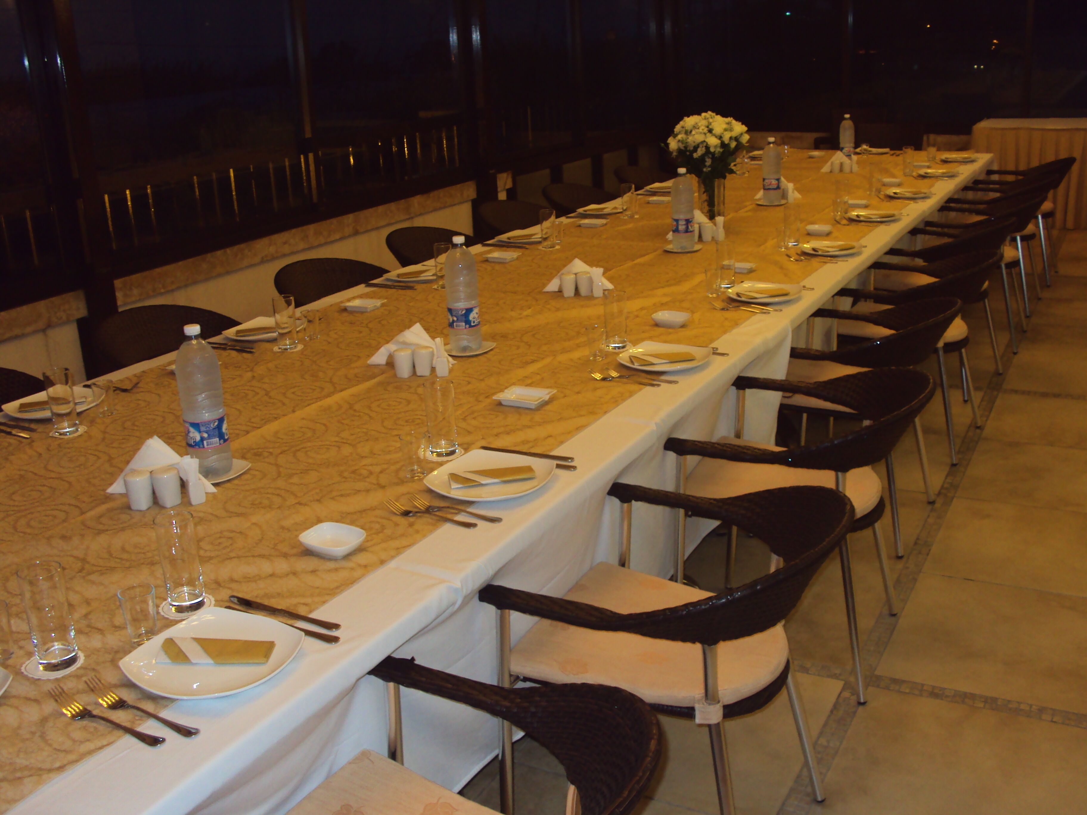 A long dining table set for a formal meal with chairs and table settings.