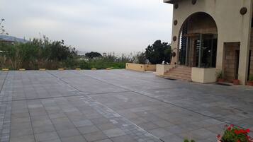 Un amplio espacio al aire libre con un sendero pavimentado que conduce a la entrada de un edificio.
