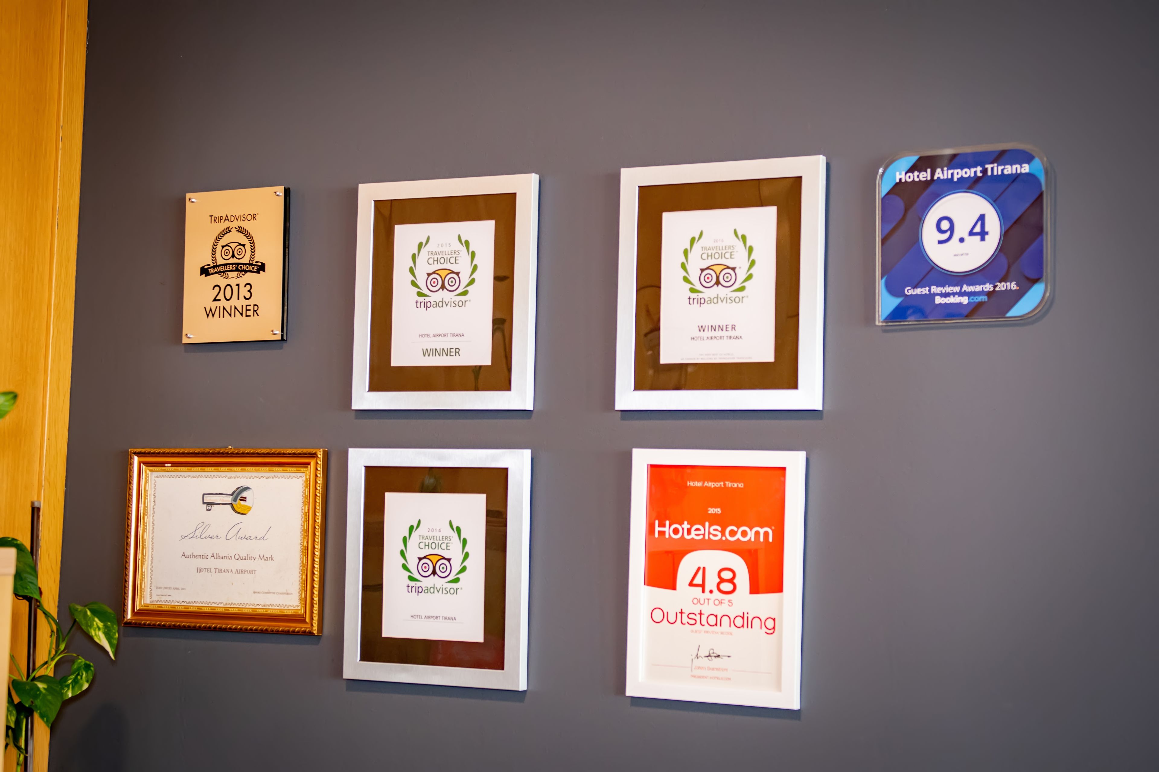 Quadros com prêmios e reconhecimentos em uma parede, incluindo prêmios TripAdvisor e Hotels.com.