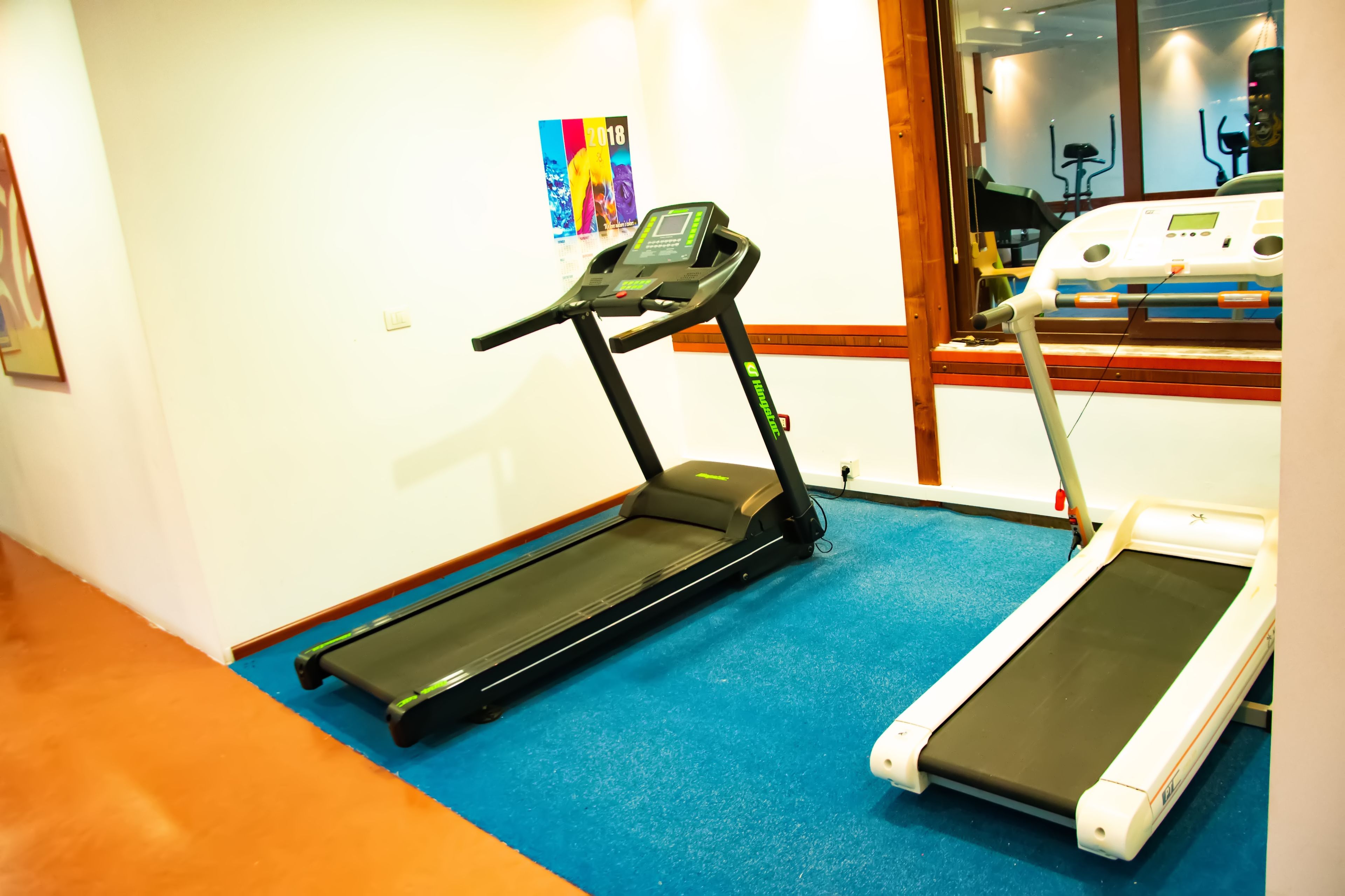Un gimnasio con cintas de correr y equipo de ejercicio.
