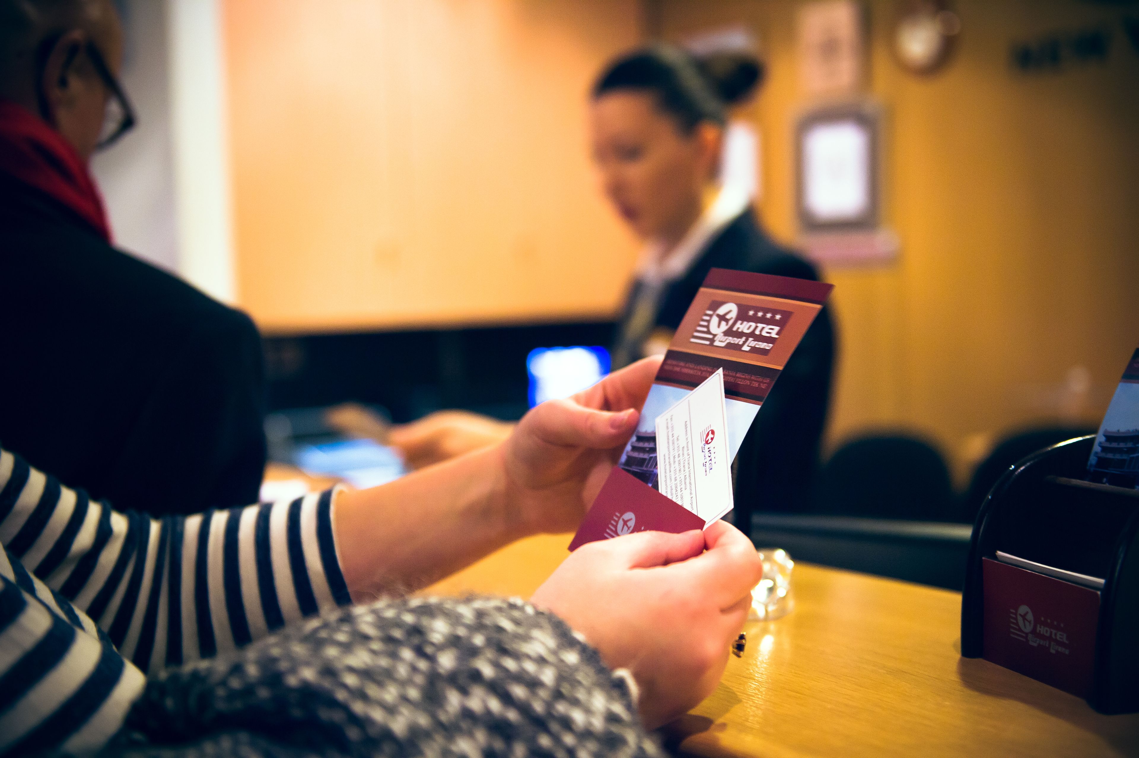 A person holding a hotel card at a reception desk.