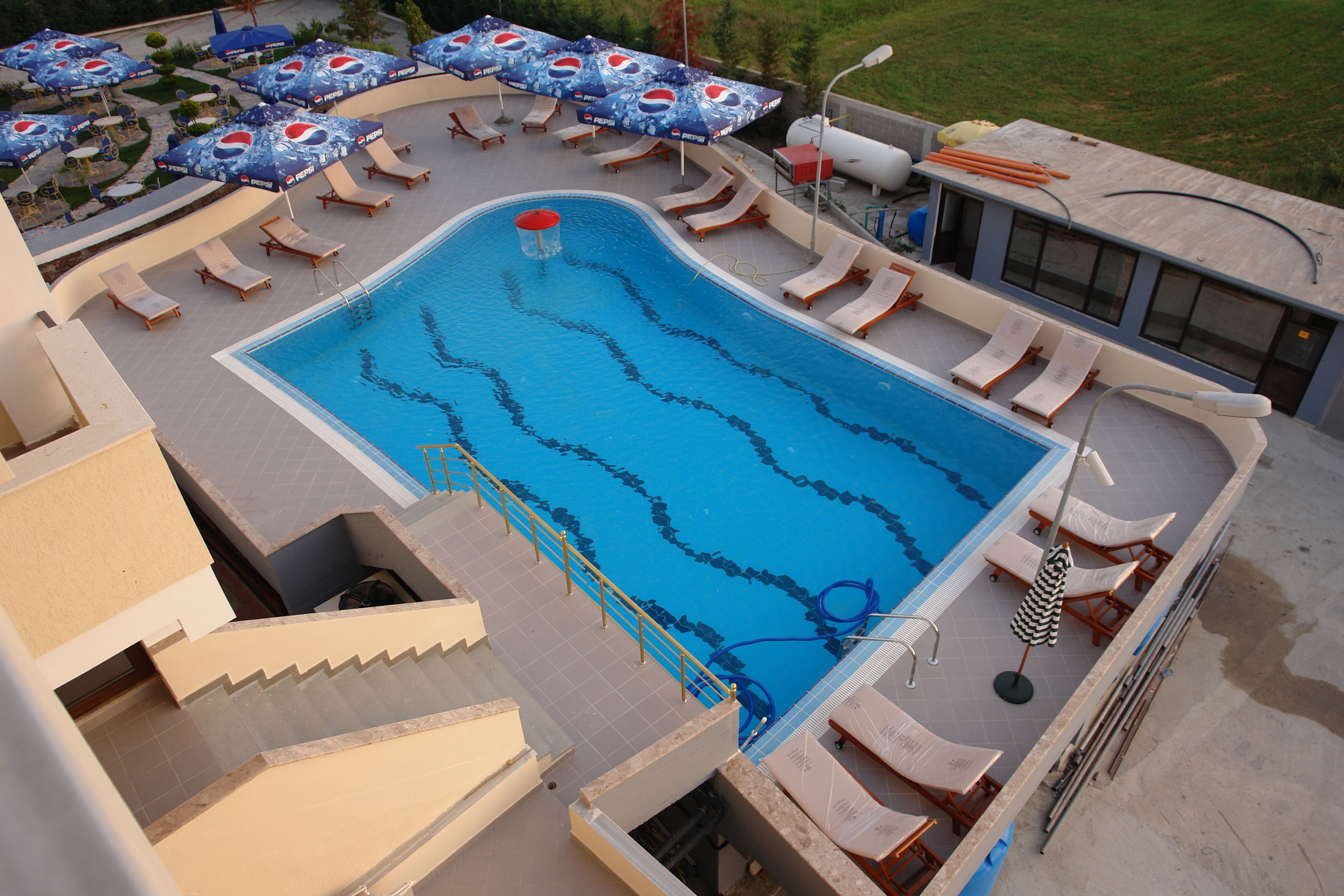 Une piscine avec plusieurs couloirs de nage, des chaises longues et des parasols.
