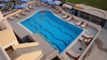 Une piscine avec plusieurs couloirs de nage, des chaises longues et des parasols.